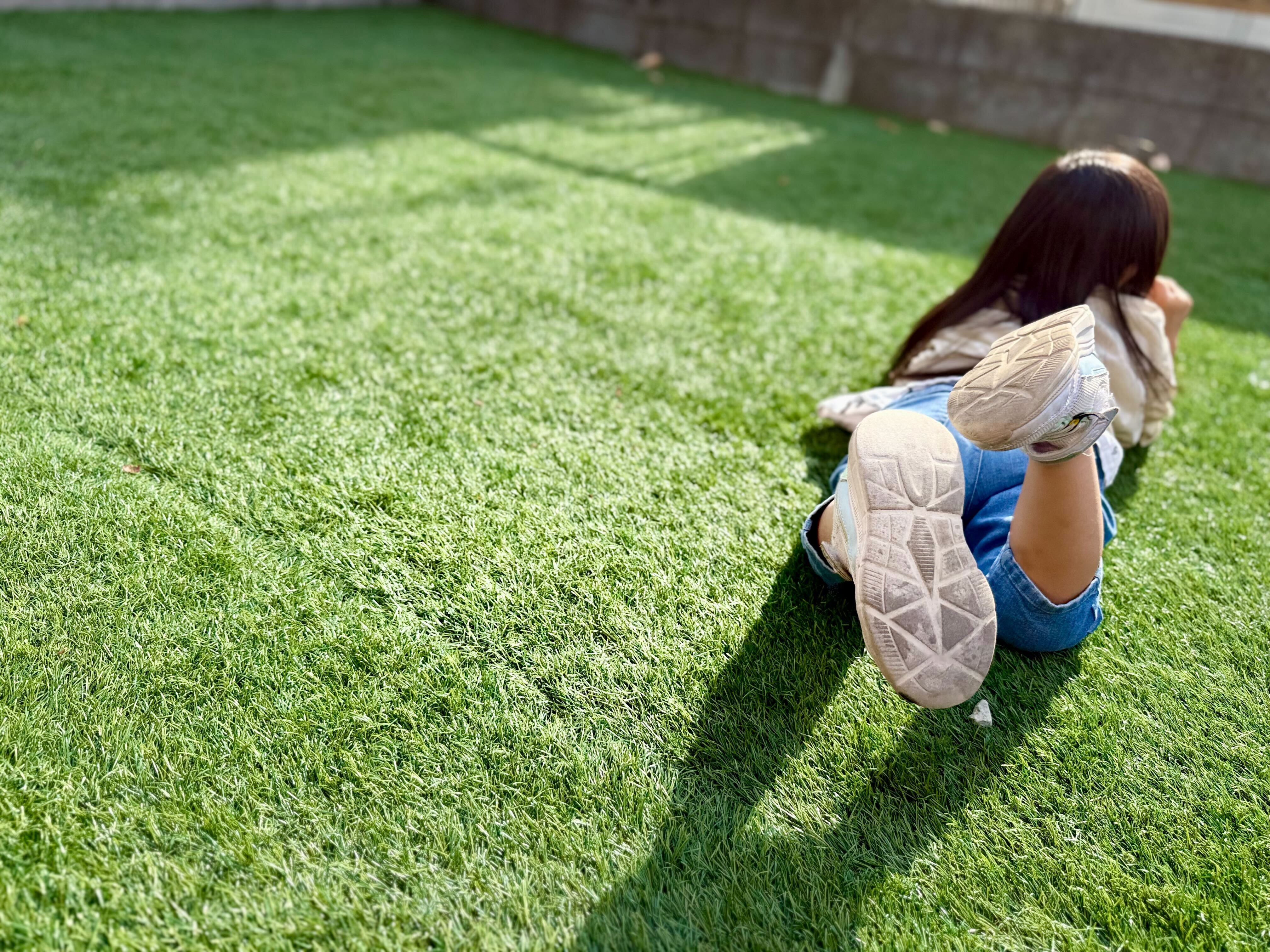 芝生の上で寝転ぶ子供